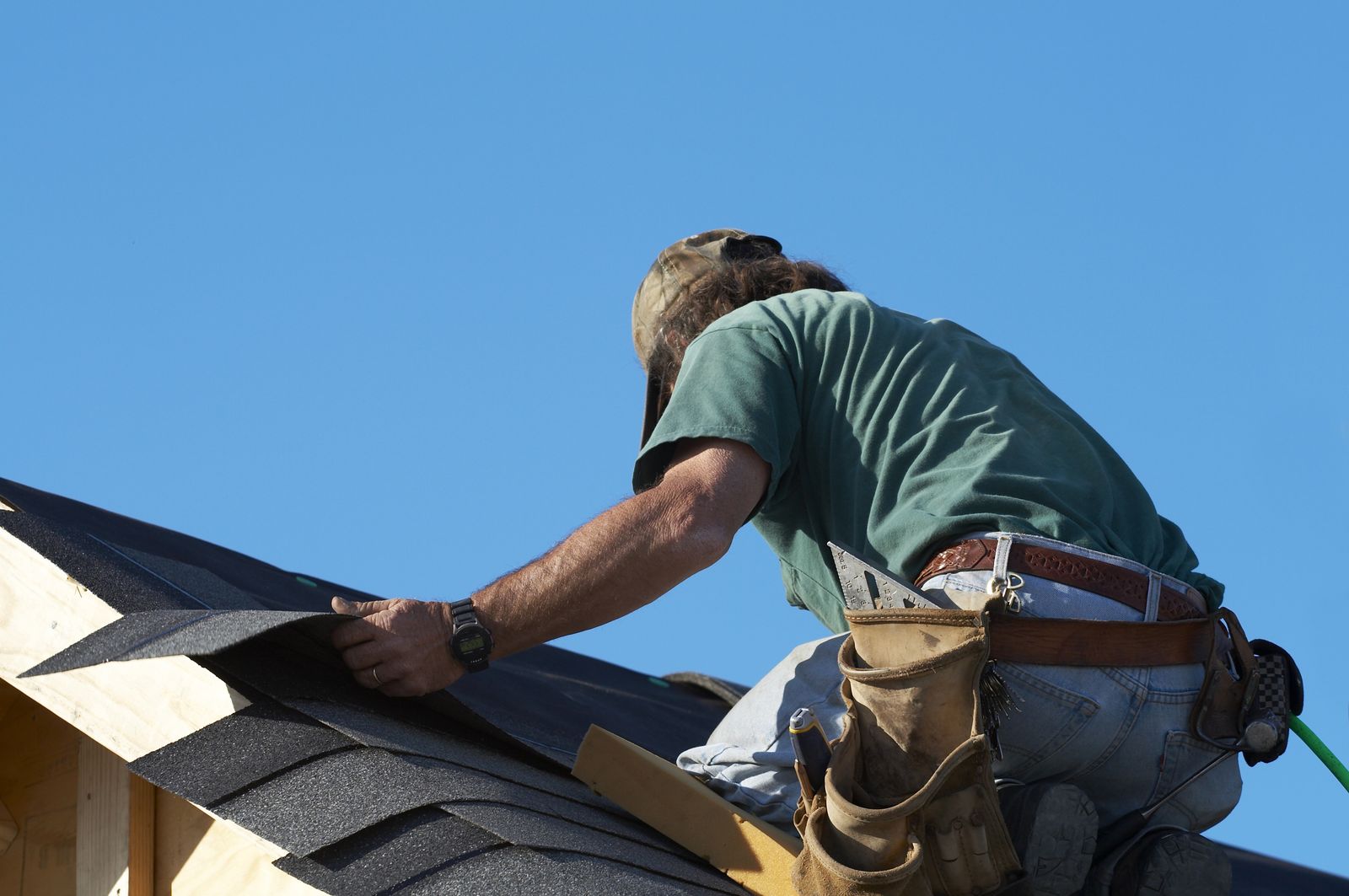 Oak Brook Roof Works crew member fastening architectural shingles on a pitched roof